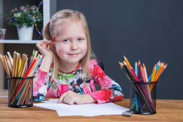 Small young girl drawing pictures with pencils