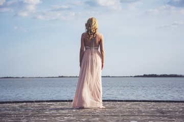 Back of blond woman in evening gown posing