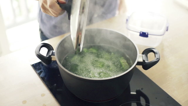 Boiling broccoli in pot in kitchen, slow motion shot at 240fps
