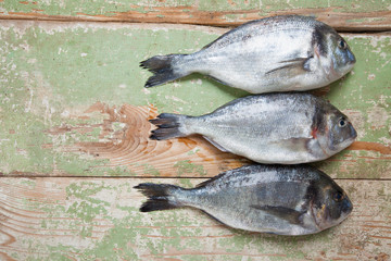 Tree fresh fishes lying on rustic wooden table