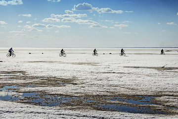 Fototapeta na wymiar Велосипедисты едут по льду Обского моря
