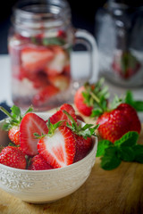 fresh ripe red strawberries in white bowl on wooden