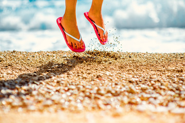 Jumping in slippers on the beach