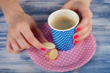 woman hands holding cup of coffee and cookie