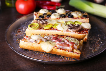 Different sandwiches with vegetables and cheese on metal tray on table close up