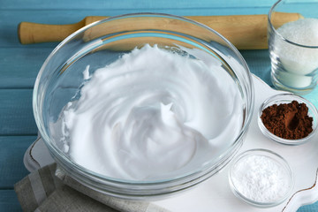 Whipped egg whites for cream on color wooden table, closeup