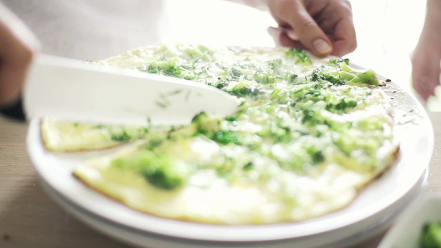 Woman hand slicing frittata omelette