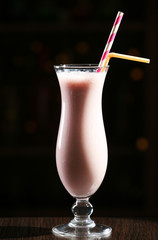 Glass of cocktail in bar on dark background