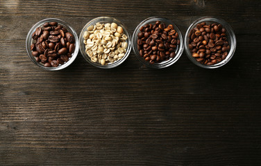 Coffee beans in saucers on wooden background