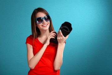 Obraz premium Young female photographer taking photos on blue background