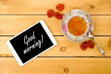The inscription "good morning" with cup of tea on wooden table