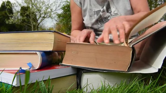outdoor Lernen aus dicken Büchern im Garten