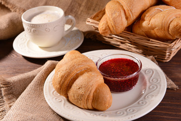 Delicious croissants on plate on table close-up