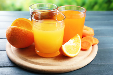 Assortment of healthy fresh juices and fruits on wooden table background