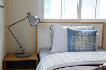 cozy bedroom interior with pillows and reading lamp on bedside t