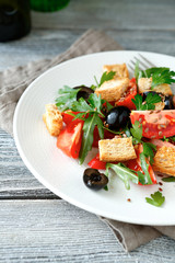 Summer salad with vegetables and toast on a white plate