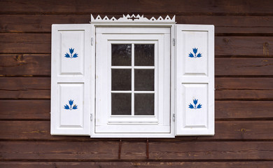 Fototapeta na wymiar Log house with decorated window