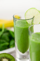 Green Smoothie with Fruits in Background