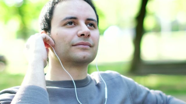 Portrait of a man listening music in a park