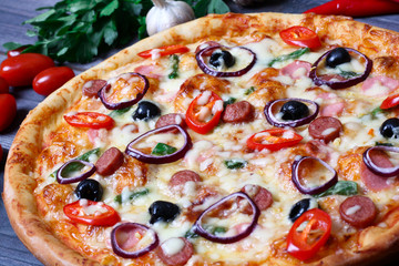 pizza with sausage, olives and chili pepper