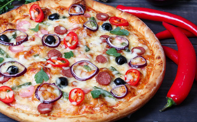 pizza with sausage, olives and chili pepper