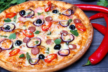 pizza with sausage, olives and chili pepper