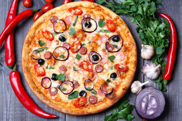 pizza with sausage, olives and chili pepper