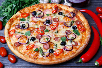 pizza with sausage, olives and chili pepper