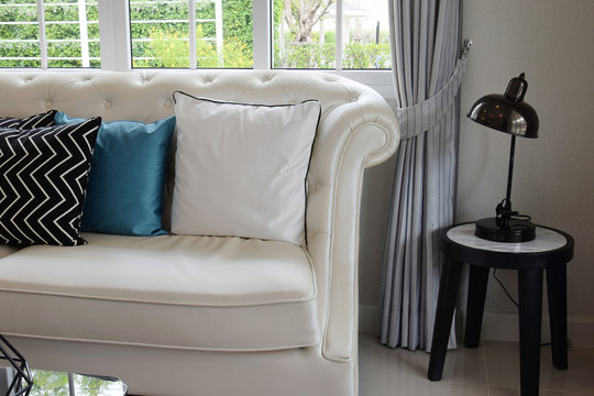 white and blue pillows on a white leather couch in vintage livin