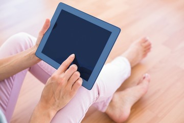 Pretty blonde woman using her tablet on the couch