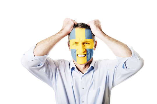 Mature man with Sweden flag on face.