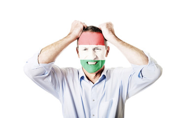 Mature man with Hungary flag on face.