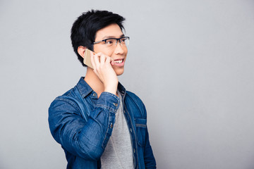 Smiling asian man talking on the phone