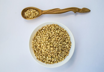 whole wheat in bowl and wooden spoon, horizontal