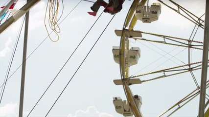 Medium panning shot of boy and girl on bungee trampoline at amusement park / Salt Lake City, Utah, United States