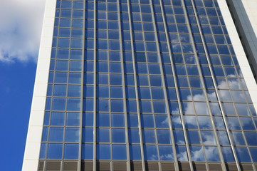 Modern building against blue sky and clouds with copy space.