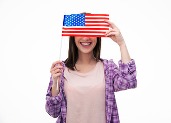 Smiling young student covering her eyes with flag