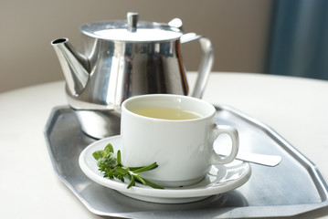 teapot and a cup with green herbal tea