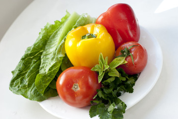 raw vegetables for salad on white plate