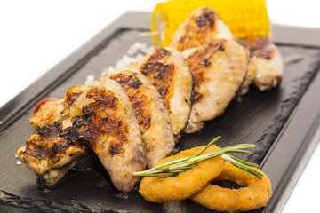 chicken wings are grilled on a wooden platter