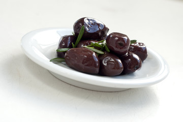 olives with rosemary on white plate