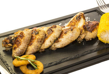 chicken wings are grilled on a wooden platter