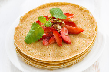 crepes with strawberries and honey ,close-up, top view