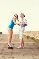 smiling couple with skateboard outdoors
