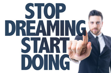 Business man pointing the text: Stop Dreaming Start Doing