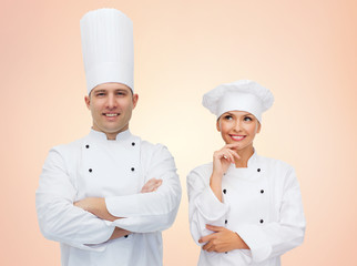 happy chefs or cooks couple over beige background