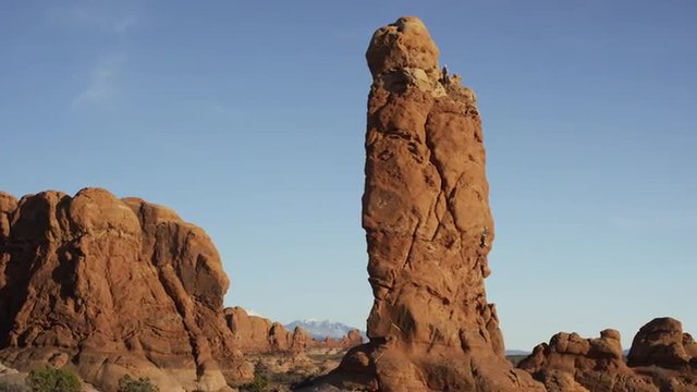 Wide panning shot of tall rock formations in national park / Arches National Park, Utah, United States