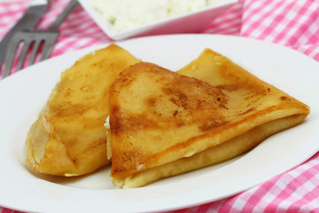 Crepes with cottage cheese on white plate