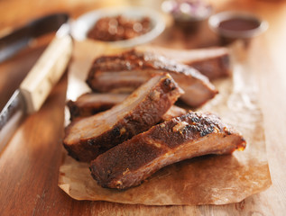 barbecue pork spare ribs on cutting board with tongs
