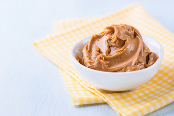 Creamy peanut butter in white bowl